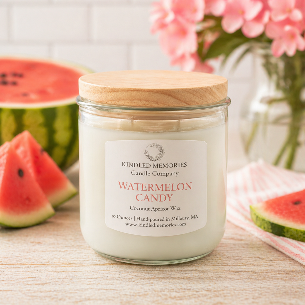 Jar of 'Watermelon Candy' candle from Kindled Memories Candle Company with watermelon slices and flowers in the background.